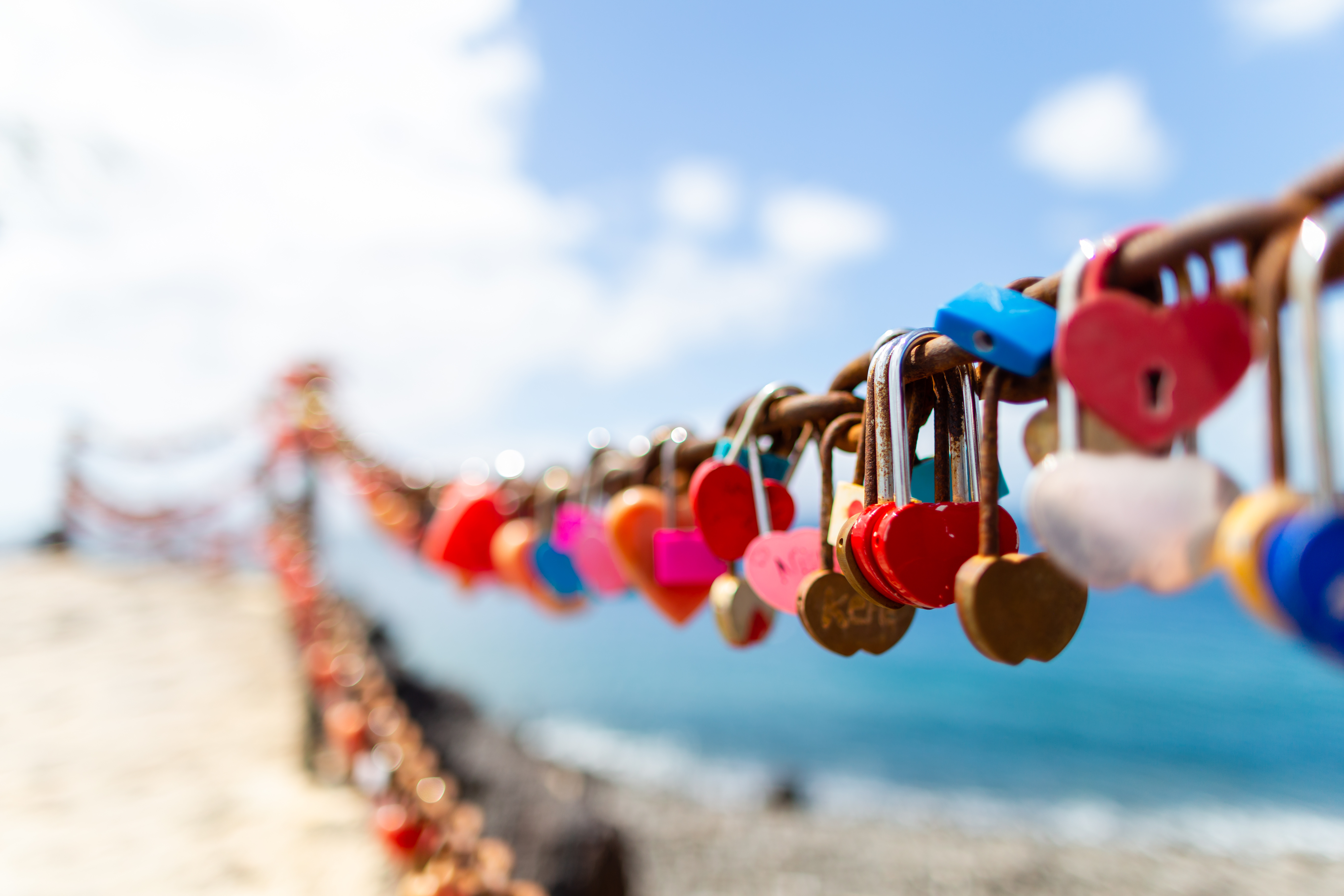 Puerto del Carmen beach in Lanzarote, Canary islands, Spain, heart shaped padlocks, blue sea.